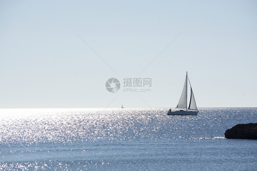 西班牙马洛卡岛的闪光帆船在阳明媚的海面上航行冬季一天有地平线西班牙马洛卡岛是月光明亮阳媚的海面上闪光帆船旅行一种自然图片