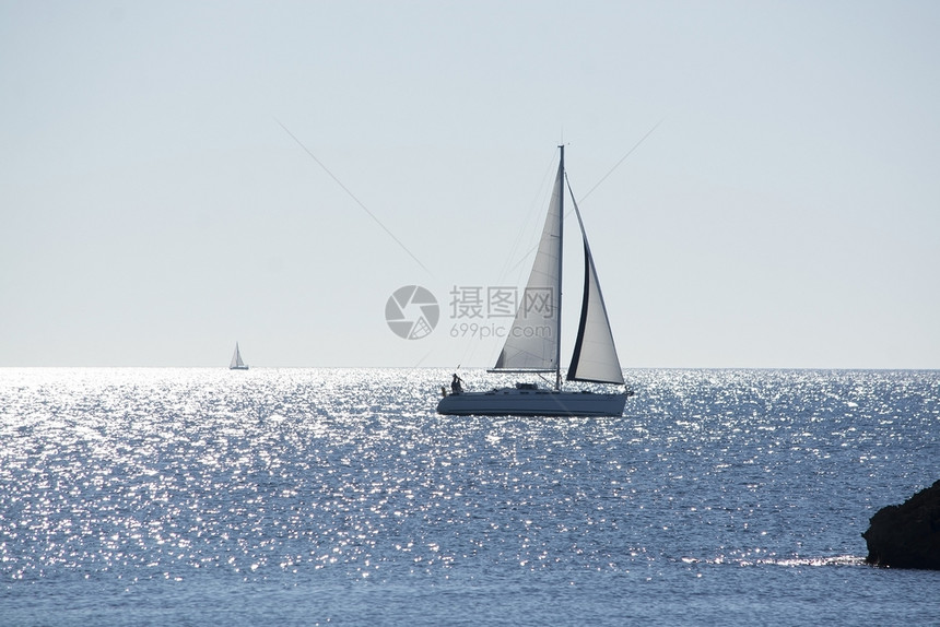 浪漫的海岸西班牙马洛卡岛的闪光帆船在阳明媚的海面上航行冬季一天有地平线西班牙马洛卡岛是月光明亮阳媚的海面上闪光帆船风图片