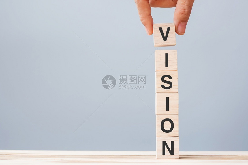 木制的创新商业男子手握木立方块在表背景战略任务和核心价值概念上用VISION商业词写在表格背景战略任务和核心价值概念上经济的图片