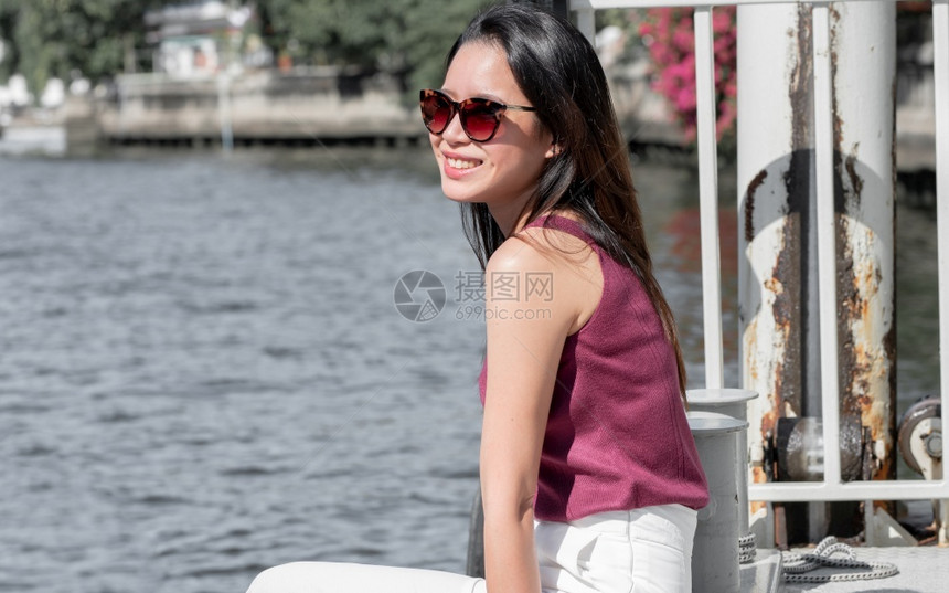 关心亚洲美丽的女身戴太阳眼镜坐在河边等船度假日暑和旅行概念SummerandTripFormation脸水图片