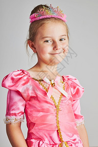 粉色皇冠有趣的假期享受公主角色的小女孩可爱56岁女孩穿着粉色公主裙和头饰站在朴素的背景上小女孩享受她的公主角色岁女孩穿着粉色公主裙和皇冠背景