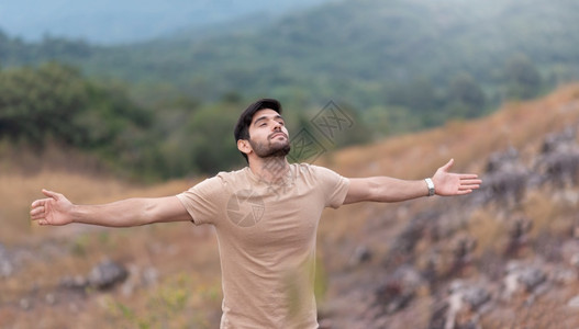 平衡早晨一个人享受着无忧虑的自由在然背景上张开双臂在山顶屏息着呼吸新鲜空气的怀抱人眼闭着睛拥抱大胡子背景图片