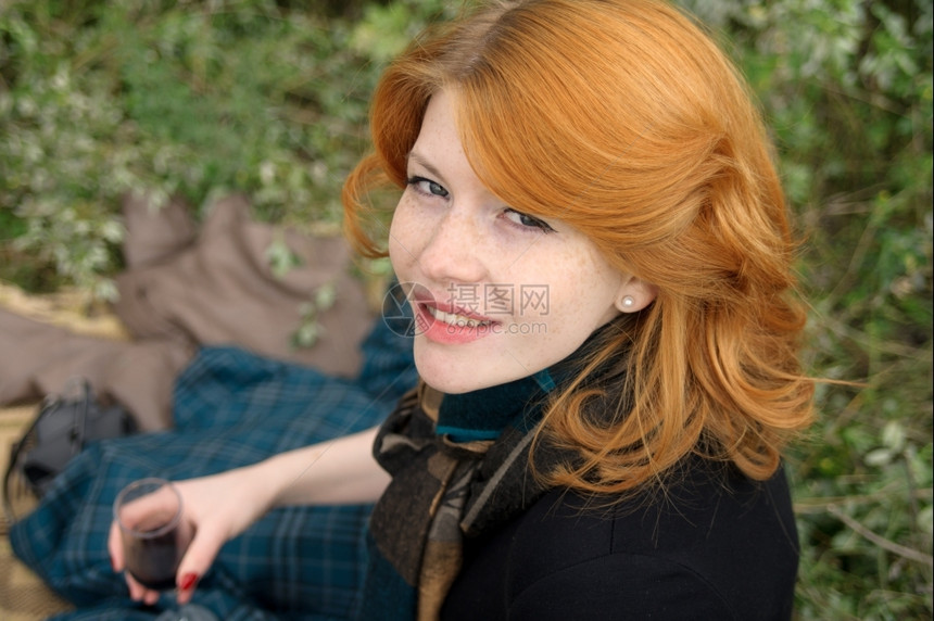 一个美丽的红头发女孩肖像在秋天公园白种人族们太阳年轻的图片