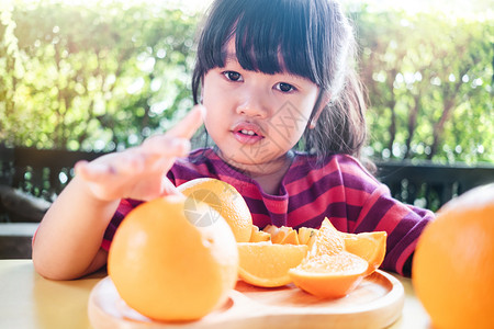 小女孩切开橘子准备食用图片
