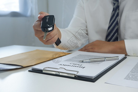 金融司机经销权在签署文档后给一辆车键的COLseup手图片