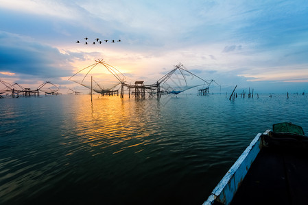 宋嫂鱼羹乡村的日出时天清晨空的美丽自然景观金色光亮鸟群飞翔当地渔具和稻草在泰国Pakpra运河BaanPakPraPhatthalung背景