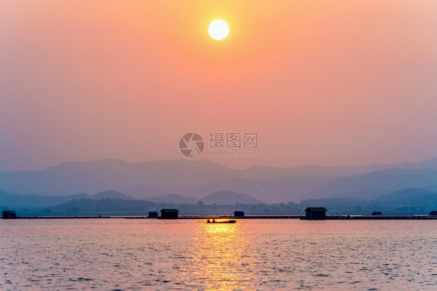 美丽的自然景观剪影渔夫在阳光下驾驶船回家日落时红橙色天空上的金光在泰国素攀武里的KrasiaoDam当地捕鱼农村生活方式日落时驾图片