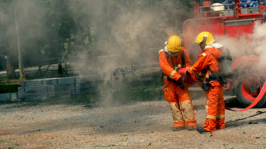 消防队员安全用水管化学泡沫喷洒剂发动机与火焰战斗的消防员Fierman戴硬帽身穿防火灭器方面的营救训练制服红色的图片