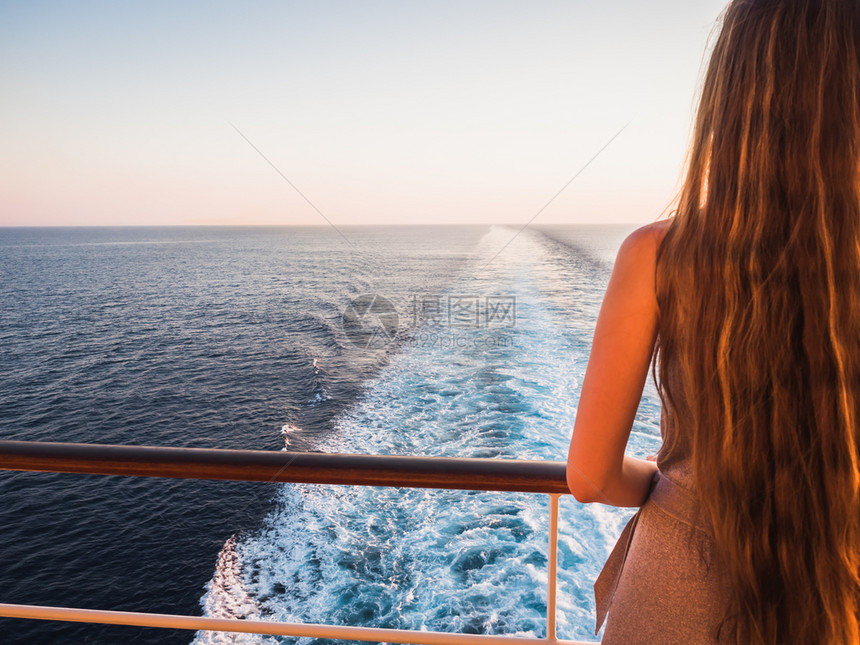 假期在海浪蓝天和日落背景的游轮空甲板上时尚美丽在空甲板上漂浮的亮女子休闲概念和旅行的时装美丽的女子在空甲板上年轻的天空图片