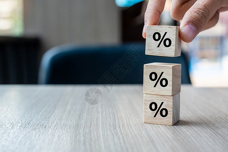 木块拼成的数字商人手放带有百分比符号图标的木块利率财务排名和抵押利率概念在线的费减少背景
