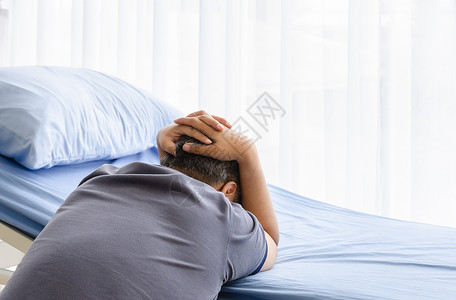 蓝色枕头患有抑郁症的老年配偶男子在病人床上悼念医院病房中已亡妻子相对的窗户天背景