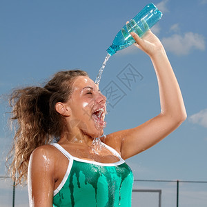 户外年轻女人用水泼她自己让凉爽热成人图片