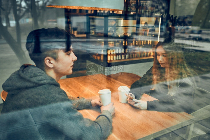 朋友聊天一起喝咖啡坐在厅里年轻男人和女在咖啡厅里放松休息等待销售买图片