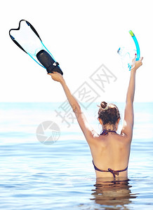 鳍游客在水深后视的中戴着脚鞋面罩和下潜腰部的棕色年轻女子海背景图片