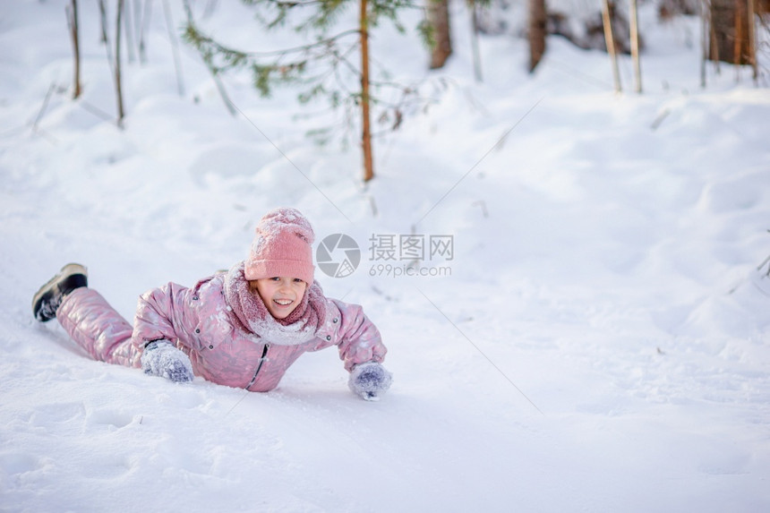 坐在雪地上玩耍的小女孩图片
