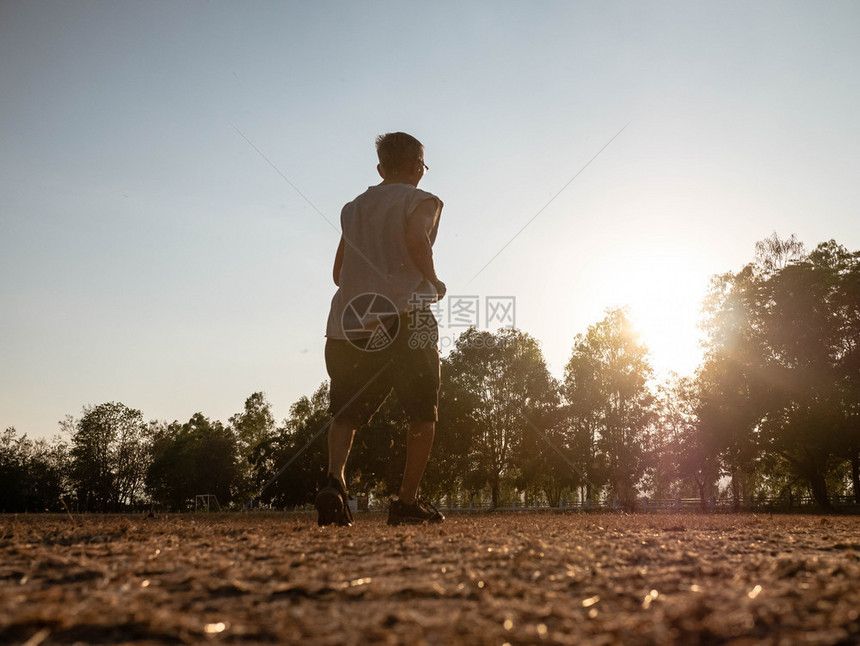 外部锻炼亚洲高年长男子在日落天空背景的公园里慢跑健康生活方式和保健概念身体图片