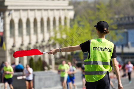 志工手上挂着指出运动员跑步的路线成功户外旗帜图片