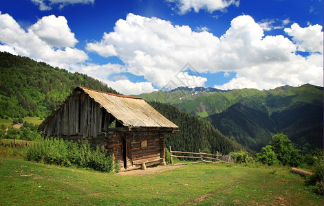 远足场景优质的山上木屋蓝色花丛天空背景图片