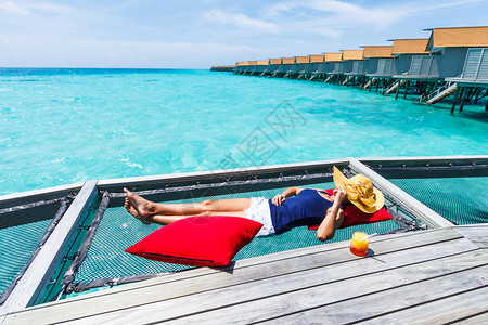 蓝色枕头蓝色的马尔代夫妇女睡在海面上平房网背景
