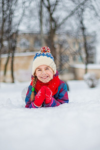 做雪人年轻的手套人们快乐女孩在下雪冬天散步玩在公园里做球冬季户外游戏快乐的女孩在下雪冬天散步玩在公园里做球背景
