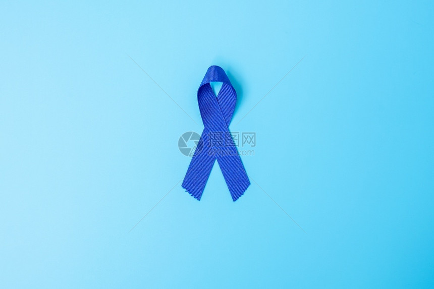 手拿蓝色丝带预防癌症概念图片