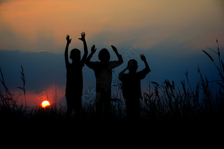 商业三个孩子的黑色轮盘一起站在日落时有天空学校女孩图片