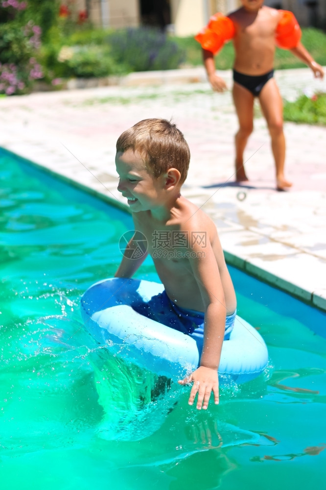 小男孩跳进游泳池玩耍图片