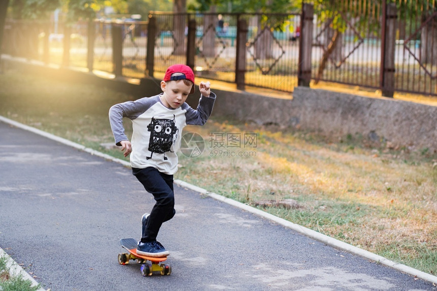 公园里玩滑板的小男孩图片