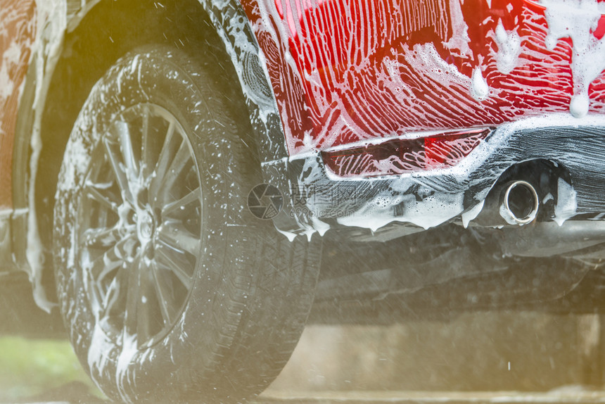 停放红色紧凑型SUV车带有运动和现代设计洗的红色小型SUV车用肥皂洗现代设计涤包括白泡沫汽车护理服务业概念在玻璃蜡和涂层汽车前用图片