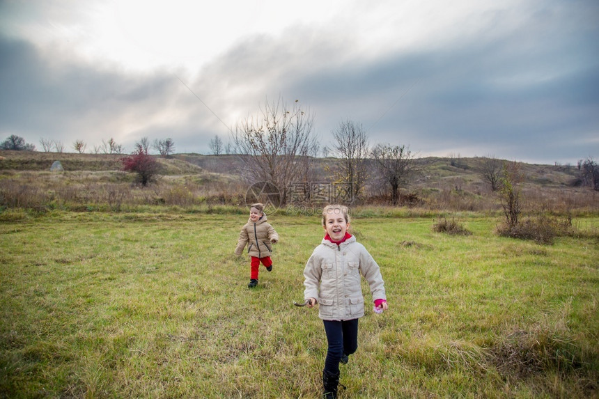 家庭乡村的农场孩子们跑进田野孩子们在黄金时段田野里玩耍鲜艳的秋色孩子们跑进田野图片