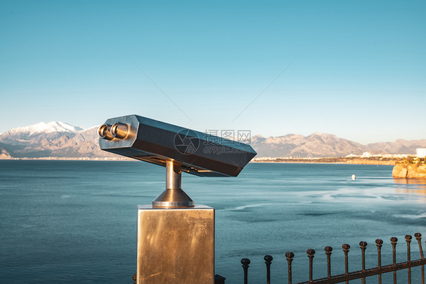 游客金属冬天土耳其安塔利亚日出时定态观测双筒望远镜土耳其固定式观察双筒望远镜天气晴朗的冬季日出图片
