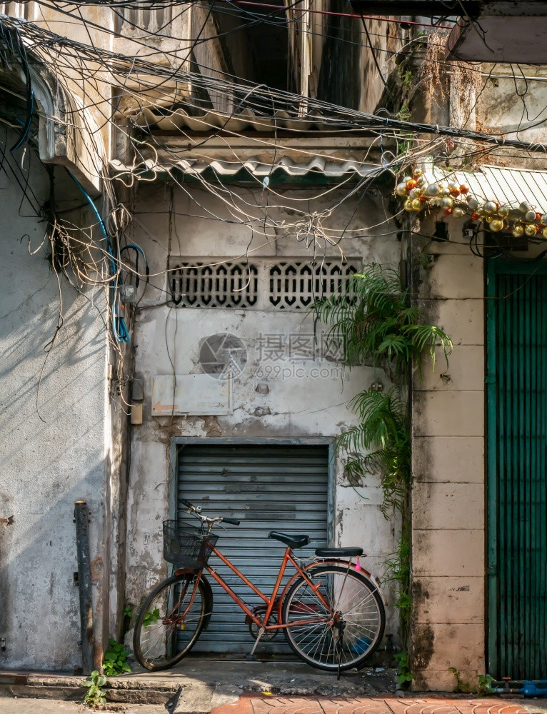 在人行道上停着自车在旧房门旁边折叠钢铁前的单人行道上停放外部砂浆图片