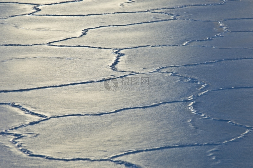 风景太阳反射在有多种裂缝的冰面上变暖美丽的图片