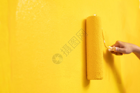 滚轴画手工人在地面墙壁上绘画用黄色彩涂漆公寓翻新留下空白的复制间以便另写描述文字以及卷离开墙纸设计图片