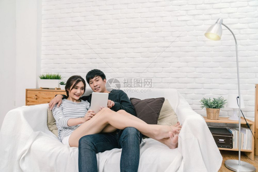 屋男人商业快乐的亚洲爱人坐着利用数字技术平板在现代家庭客厅沙发上自拍两者成功和生活方式概念一图片