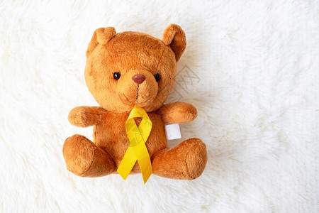 泰迪熊与黄色丝带预防癌症概念高清图片
