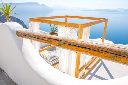美丽的希腊语火山口伊亚阳光明媚的天气一个享受日光浴的地方可以欣赏到大海和岛屿的全景在圣托里尼岛的一家酒店里享受日光浴背景图片
