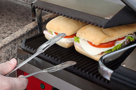 国内的黄油用具在烤面包机里准备一个快速健康的三明治图片