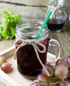 木桌上的鲜葡萄和果汁混合季节紫色的图片