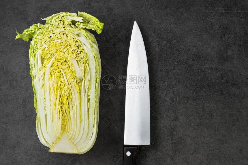 最佳生动健康在灰色桌子上厨师刀旁边一半的北京卷心菜烹饪沙拉图片