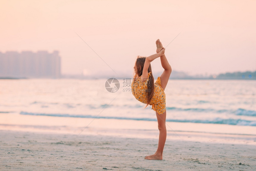 阿布迪拜日落时在白沙滩上可爱的快乐小女孩日落时在白沙滩上可爱的快乐小女孩趣旅行图片