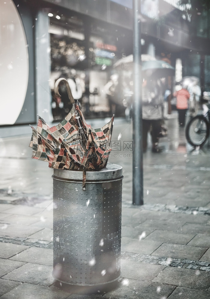 在冬季雪暴中购物街区的垃圾桶里断了的雨伞粉色面纱潮流美丽的鼓舞人心情调消退了风景欧洲的旅行暴风雪图片