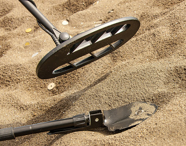 污垢磁的沙滩上金属探测器环和铲子金图片