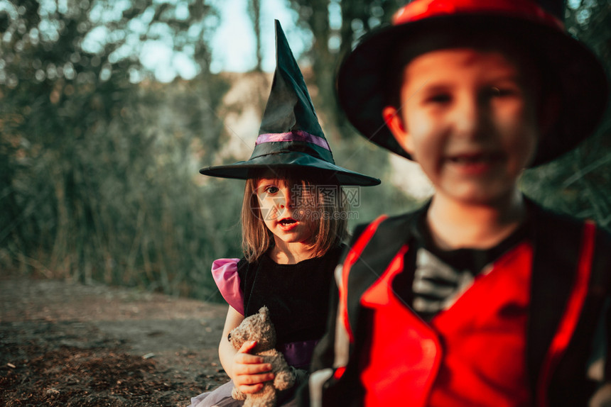 两个孩子在树林里伪装成万圣节乐趣微笑黑色的图片
