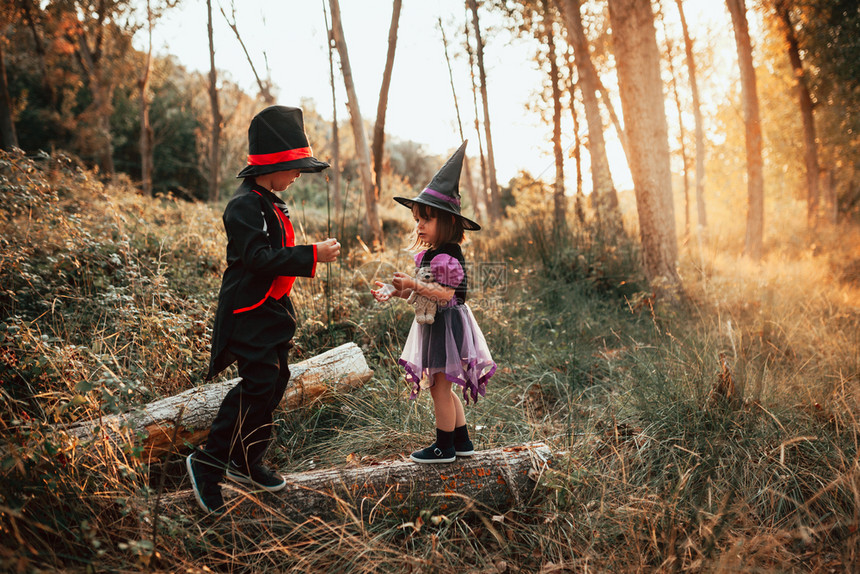 骨骼两个孩子在树林里伪装成万圣节假期庆祝图片