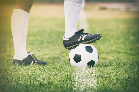 足球锦标赛足球或运动员站在场上踢足软焦点和选择在草地上团队计分男背景