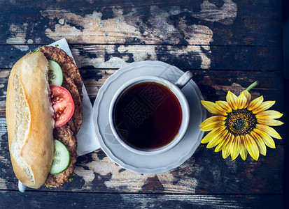 早餐沙拉酱午加面包肉丸番茄和黄瓜以及木制背景的茶杯图片