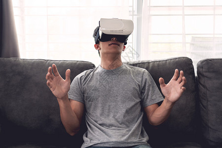 观众庆典一个快乐的男人坐在沙发上戴着3D虚拟真人眼镜获胜图片