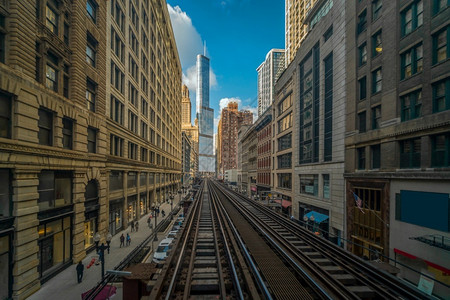 美国伊利诺州芝加哥环线大楼之间铁路轨道上方的迹正在运行公路轨迹位于美国伊利诺州芝加哥环线玻璃乘客速度背景图片