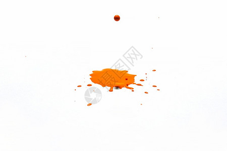 微距摄影橙色水滴喷洒在白背景上单身的白色图片